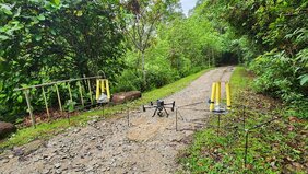eigt zwei Stationen mit Aufzeichnungsgeräten, die von der in der Mitte abgebildeten Drohne in die Baumkronen hinaufbefördert wurden.