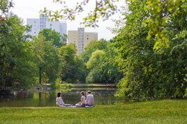 Menschen im Park vor Hochhäusern