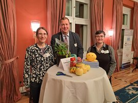 Drei Personen stehenan einem Tisch