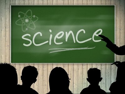 Studenten als Schattenrisse; Im Hintergrund Tafel mit Schriftzug "Science"