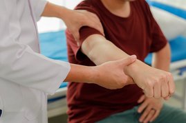 Ein Mensch hält den Arm eines anderen Menschen fest