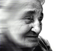 Schwarz-weiß-Foto einer nach rechts blickenden alten Frau im Halbprofil. Nach links (zu den Haaren hin) verwischt.