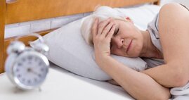 Älltere Frau liegt im Bett und schläft