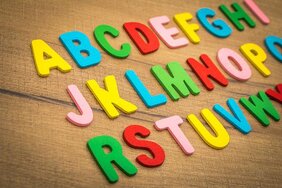 Buntes Alphabet auf braunem Hintergrund