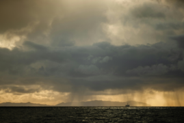 Küstenstreifen mit Regenwolken