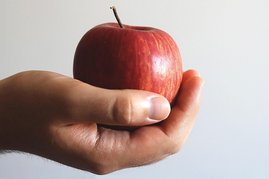 Eine Hand hält einen Apfel