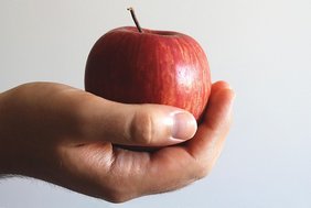 Eine Hand hält einen Apfel
