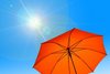 Mehr Sonne, mehr UV-Risiko Blauer Himmel mit Sonne und Sonnenschirm
