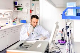 Dr. Micha Banz bei der Vorbereitung einer Sequenzierbibliothek: Mit der Pipette wird eine aufgereinigte DNA-Probe für die Analyse auf eine Sequenziereinheit aufgebracht. 