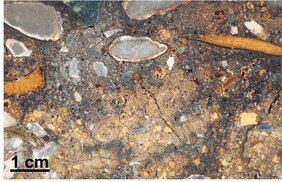 Oberfläche eines in Kunststoff imprägnierten Sedimentblocks aus der Denisova-Höhle. 