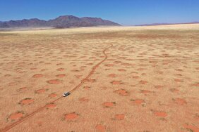 Drohnenaufnahme eines Autos im NamibRand-Naturreservat, eine der Feenkreisregionen in Namibia