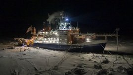 Das deutsche Forschungsschiff Polarstern liegt während der Polarnacht an einer Eisscholle vor Anker. 
