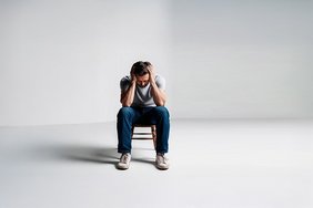 Long-COVID besser verstehen Ein Mann sitz erschöpft auf einem Stuhl