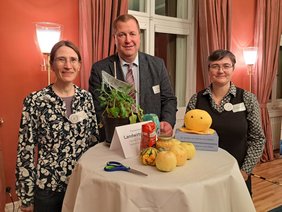 Drei Personen stehenan einem Tisch