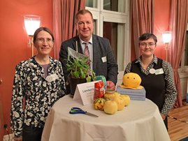 Drei Personen stehenan einem Tisch