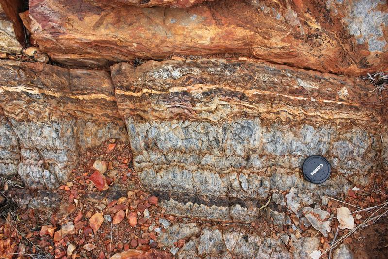 Frei an der Oberfläche liegendes Gestein des Pilbara-Kratons: unten graues Baryt-Gestein, oben durch Oxidation rötlich gefärbte Stromatolithen 